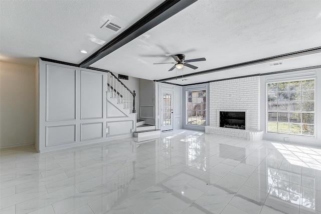 unfurnished living room featuring ceiling fan, a textured ceiling, and a fireplace