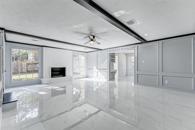 unfurnished living room featuring plenty of natural light, a brick fireplace, and a textured ceiling