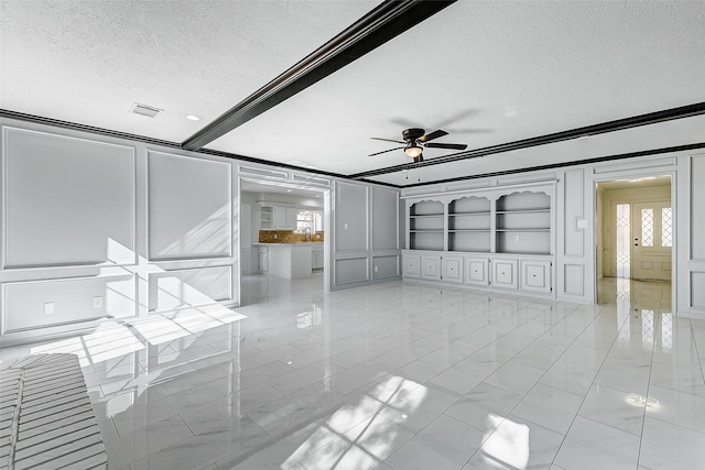 unfurnished living room with beam ceiling, ceiling fan, a textured ceiling, and built in shelves