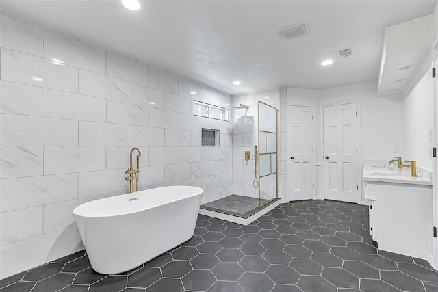 bathroom featuring vanity, tile patterned floors, shower with separate bathtub, and tile walls