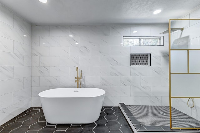 bathroom featuring independent shower and bath, tile patterned flooring, and tile walls