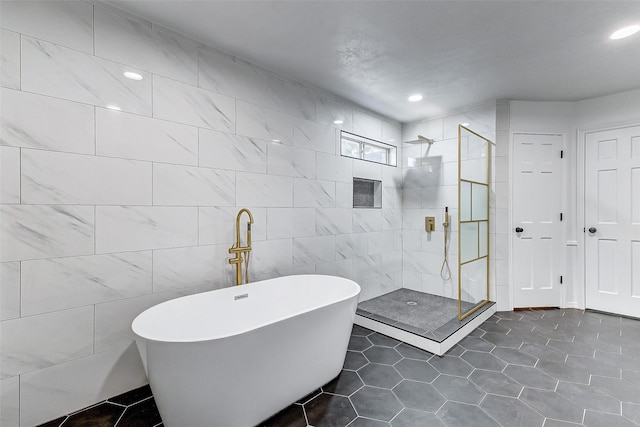 bathroom with tile walls, tile patterned floors, and plus walk in shower