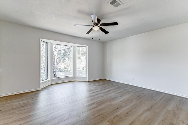 unfurnished room featuring ceiling fan, a textured ceiling, and light wood-type flooring