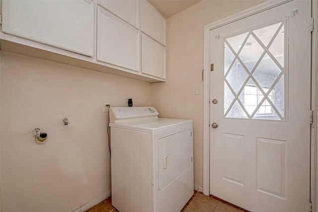 clothes washing area with washer / clothes dryer, light tile patterned floors, and cabinets