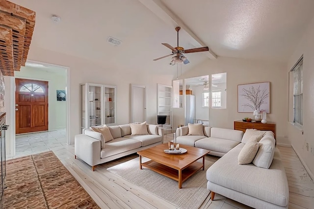 living room featuring vaulted ceiling with beams, ceiling fan, and light wood-type flooring