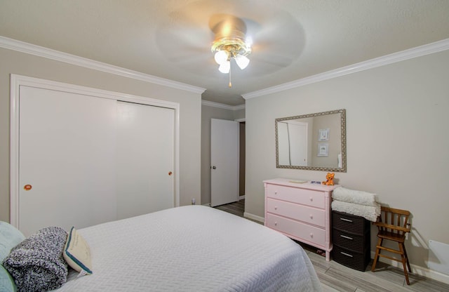 bedroom with ceiling fan, ornamental molding, a closet, and light wood-type flooring