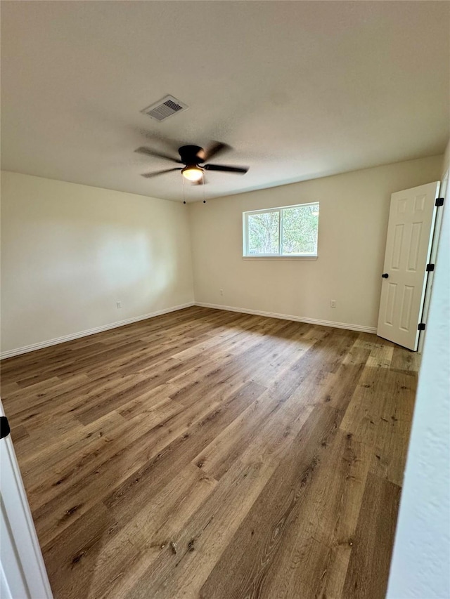 empty room with hardwood / wood-style flooring and ceiling fan