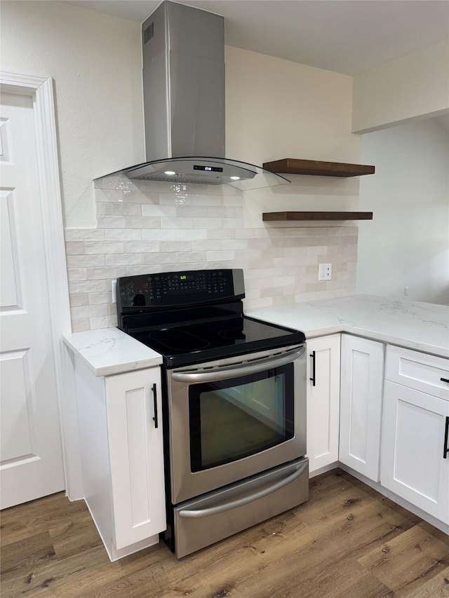 kitchen featuring dark wood-type flooring, extractor fan, white cabinetry, stainless steel range with electric stovetop, and light stone countertops