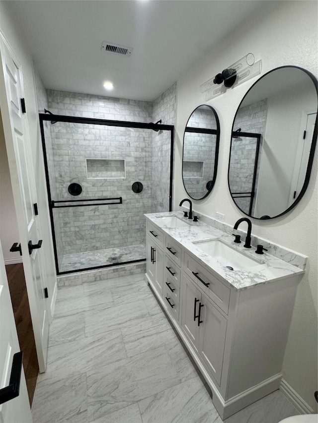 bathroom with vanity and a shower with door