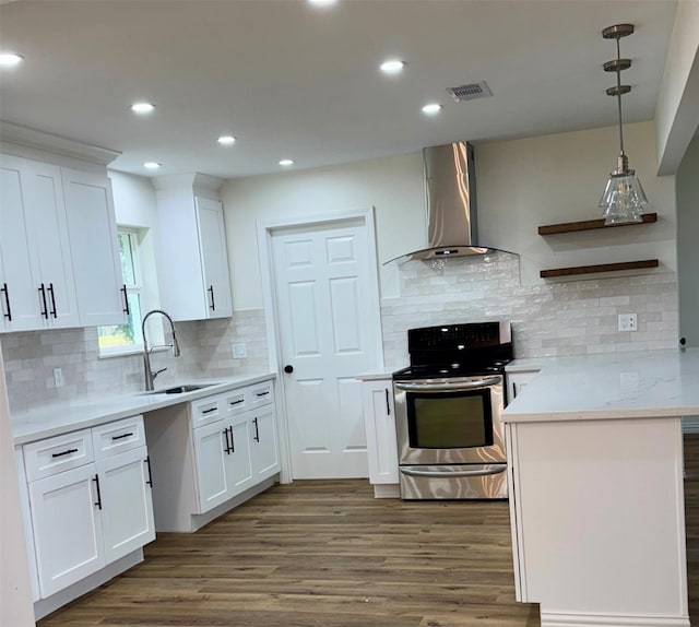 kitchen with white cabinetry, stainless steel range with electric stovetop, sink, and wall chimney range hood