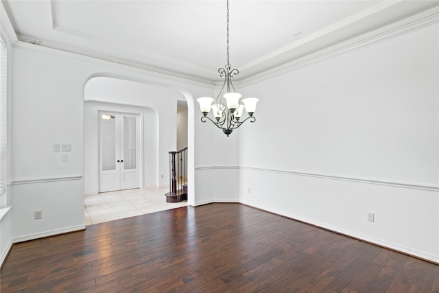 empty room with crown molding, a tray ceiling, and light hardwood / wood-style flooring