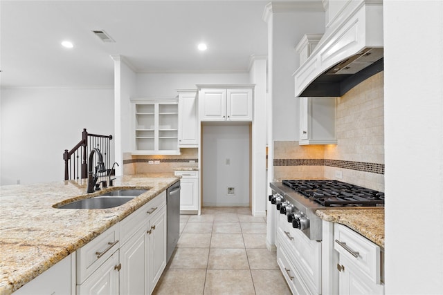 kitchen featuring sink, premium range hood, stainless steel appliances, light stone counters, and white cabinets