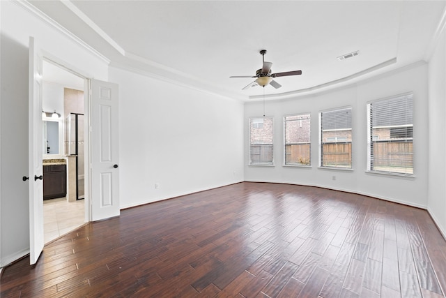 spare room with ceiling fan, ornamental molding, a raised ceiling, and hardwood / wood-style floors