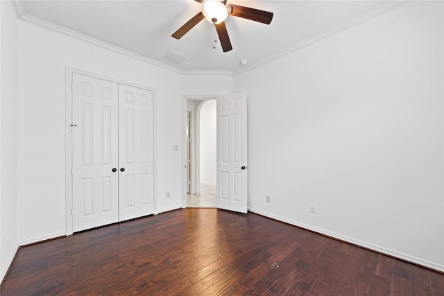 unfurnished bedroom with dark hardwood / wood-style flooring, ornamental molding, a closet, and ceiling fan