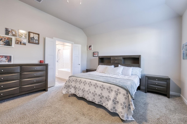 carpeted bedroom featuring ensuite bath, visible vents, baseboards, and vaulted ceiling