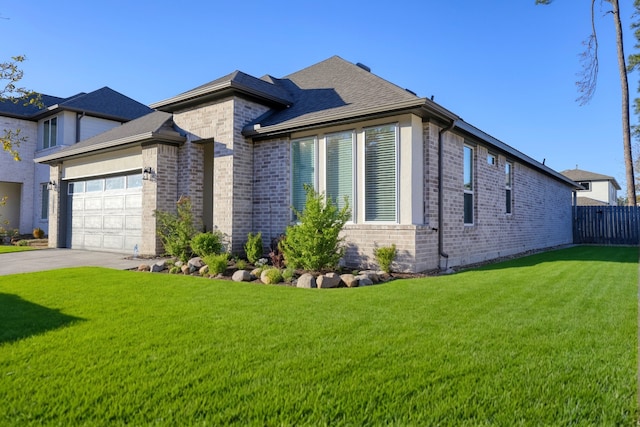 view of front facade featuring an attached garage, a front lawn, concrete driveway, and brick siding