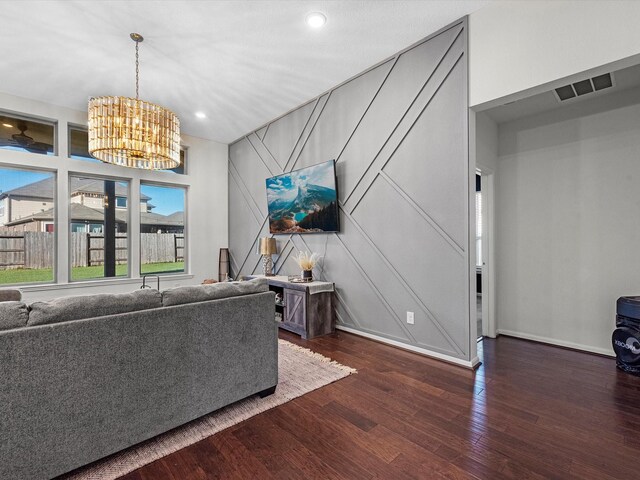 unfurnished living room featuring a notable chandelier and dark wood-type flooring