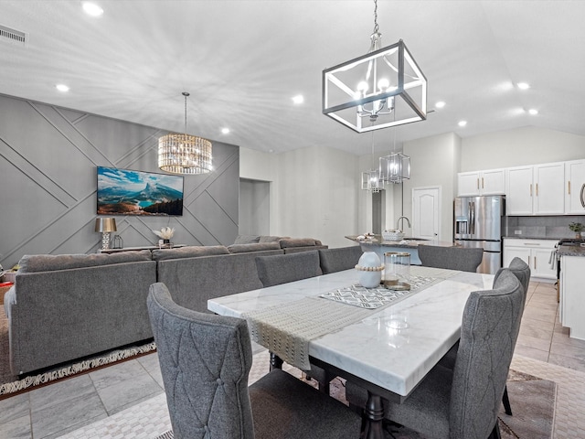 tiled dining room with a notable chandelier, vaulted ceiling, and sink