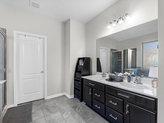 bathroom with an enclosed shower, vanity, and tile patterned floors