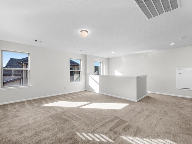 empty room featuring light carpet and a textured ceiling