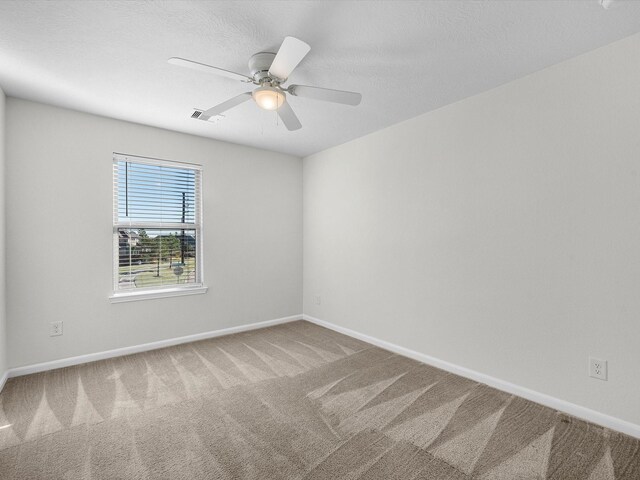 spare room featuring carpet, a textured ceiling, and ceiling fan