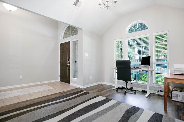 office space with dark wood-type flooring, a notable chandelier, and high vaulted ceiling