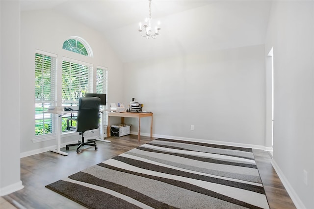 office area with dark hardwood / wood-style floors, high vaulted ceiling, and a notable chandelier