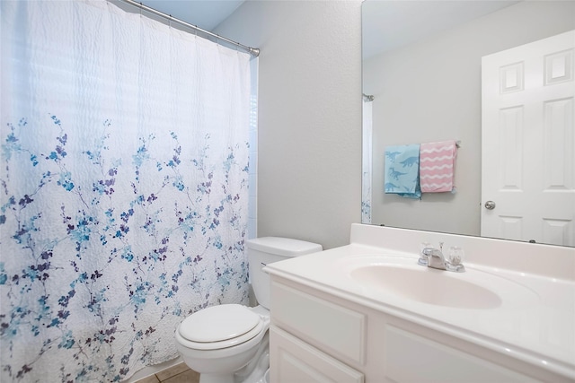 bathroom featuring tile patterned floors, vanity, toilet, and curtained shower