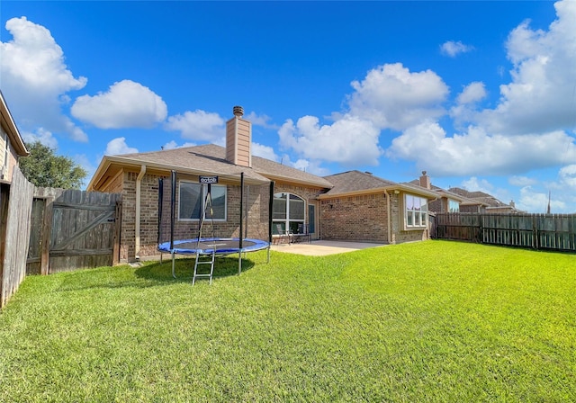 back of property with a patio area and a lawn