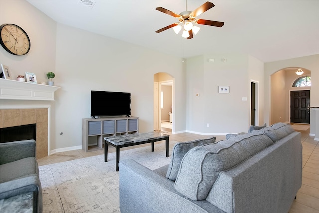 living room featuring ceiling fan, light tile patterned flooring, and a fireplace