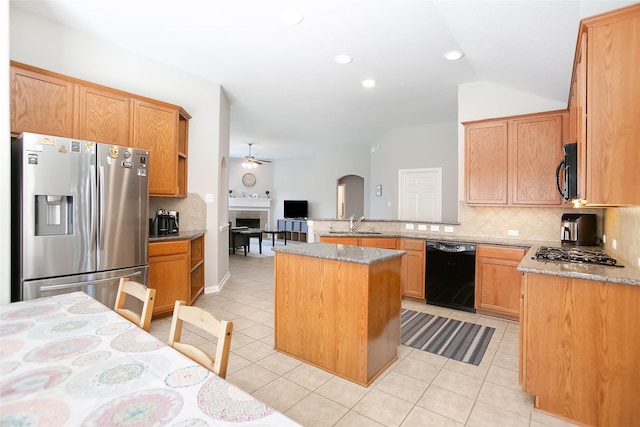 kitchen with light stone counters, light tile patterned floors, black appliances, and a center island