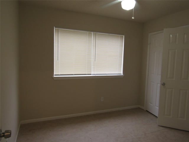 unfurnished bedroom with light tile patterned floors and ceiling fan