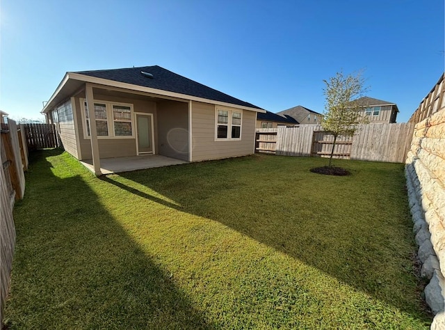 rear view of property featuring a patio and a yard