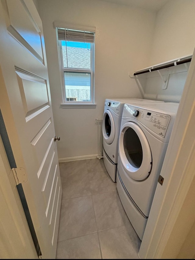 laundry room with washing machine and clothes dryer and light tile patterned floors