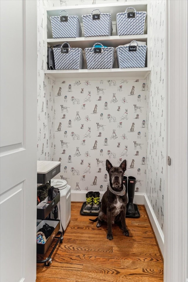 interior space featuring light wood finished floors, wallpapered walls, and baseboards