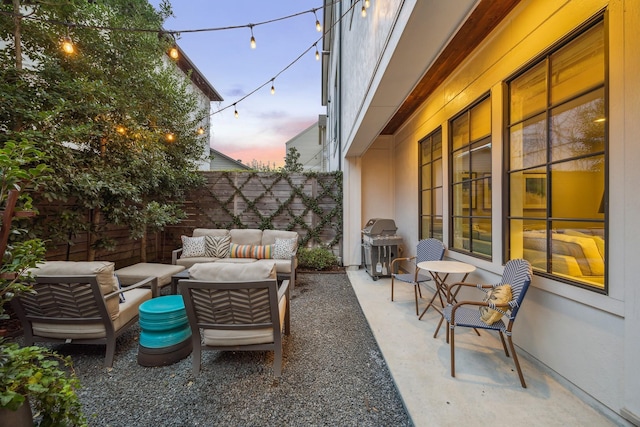 patio terrace at dusk with area for grilling and an outdoor living space