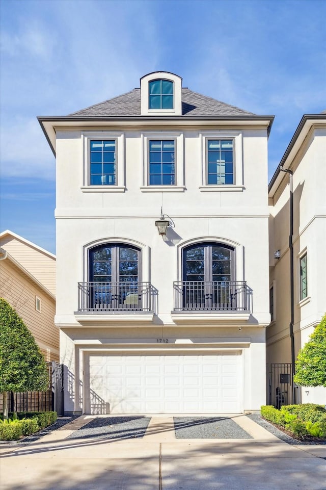 view of front of house with stucco siding, an attached garage, driveway, and fence