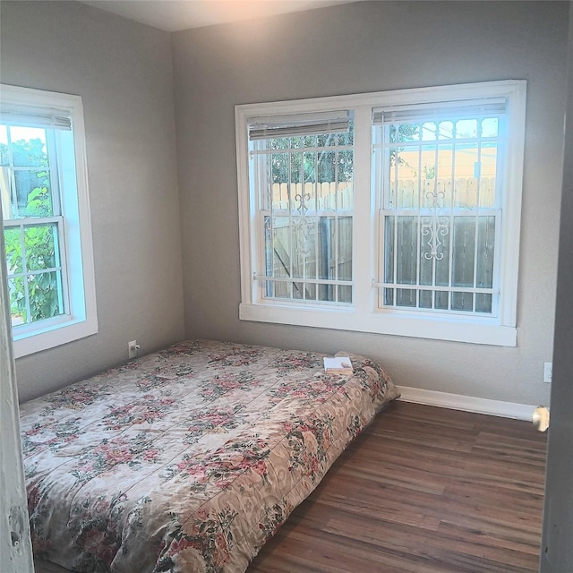 bedroom featuring dark hardwood / wood-style flooring and multiple windows