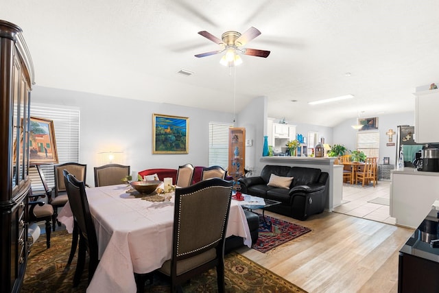 dining area with vaulted ceiling, ceiling fan, and light hardwood / wood-style floors