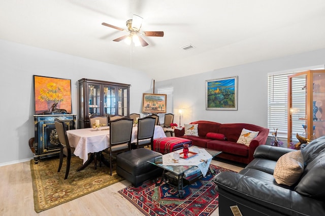 living room with ceiling fan, lofted ceiling, and light wood-type flooring