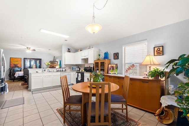 dining space featuring ceiling fan, lofted ceiling, and light tile patterned floors