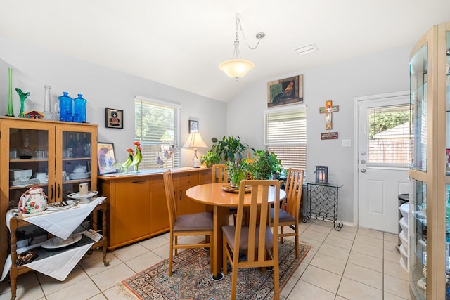 dining space with lofted ceiling, light tile patterned floors, and a wealth of natural light