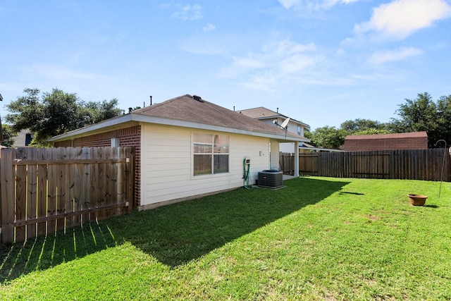 back of property featuring a yard and central air condition unit