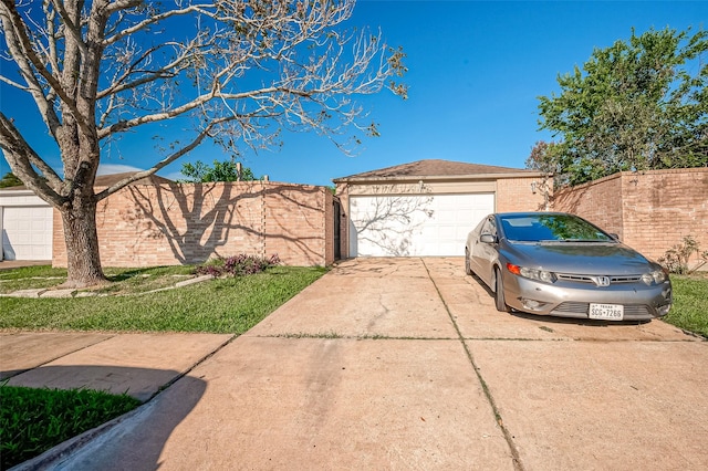 view of front facade featuring an outbuilding, concrete driveway, and fence