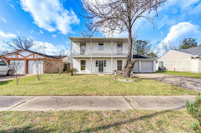 view of front of house featuring a garage, a front yard, a balcony, and a porch