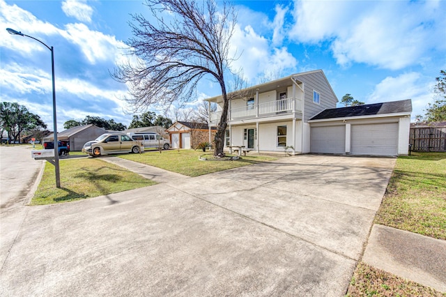 view of property with a garage, a balcony, and a front lawn