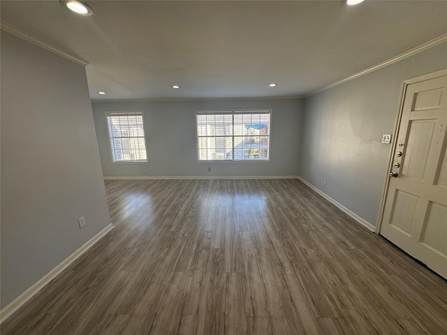 empty room featuring crown molding and dark wood-type flooring