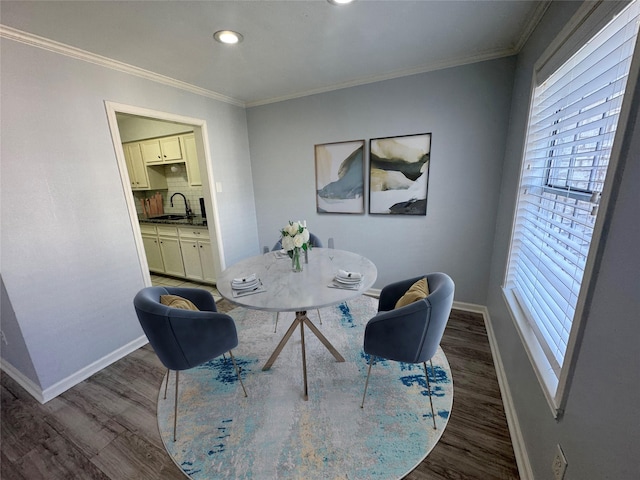 dining room featuring sink, crown molding, and dark hardwood / wood-style floors