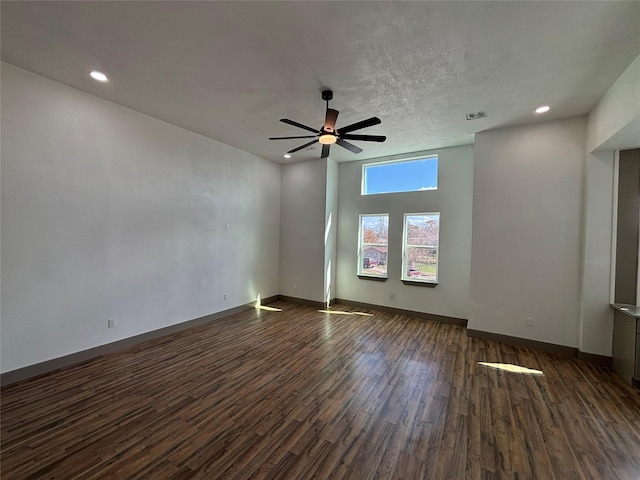 spare room featuring dark wood-type flooring, ceiling fan, and a textured ceiling