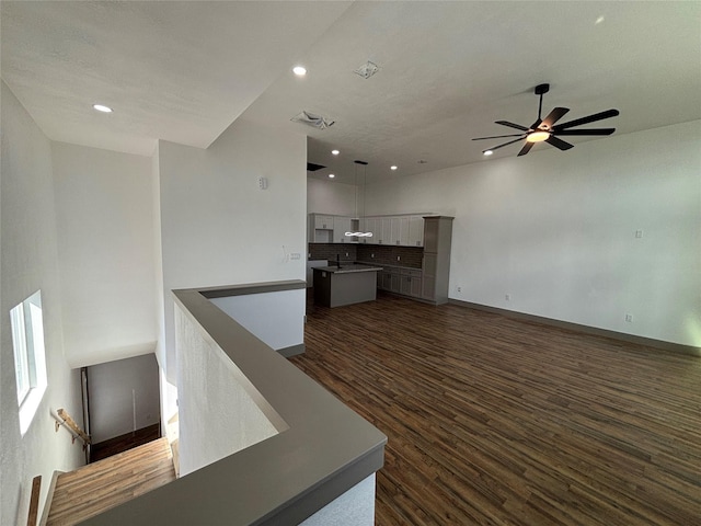 unfurnished living room with dark hardwood / wood-style floors, sink, and ceiling fan